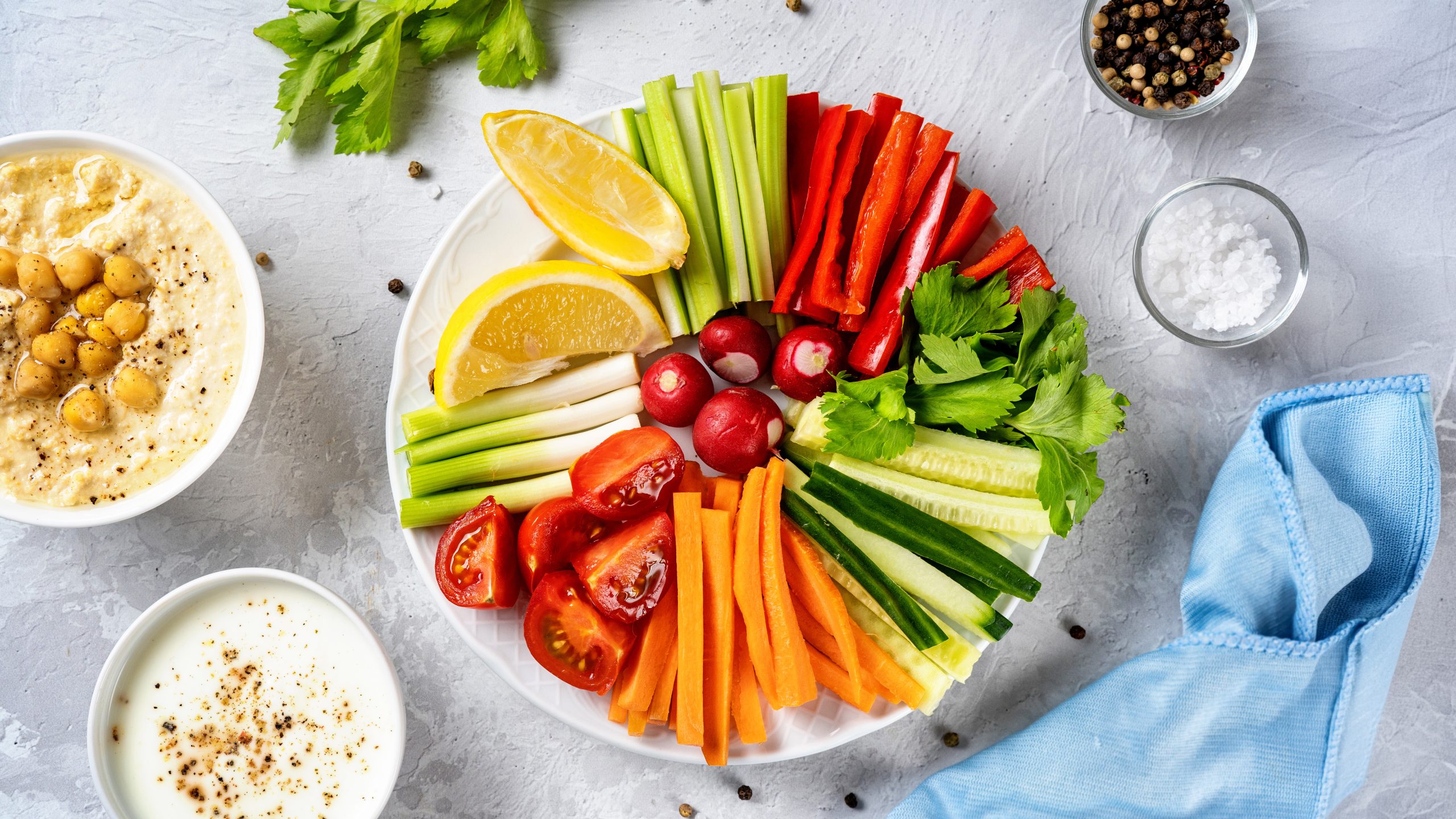 Close up of a plate with cut vegetables and dips