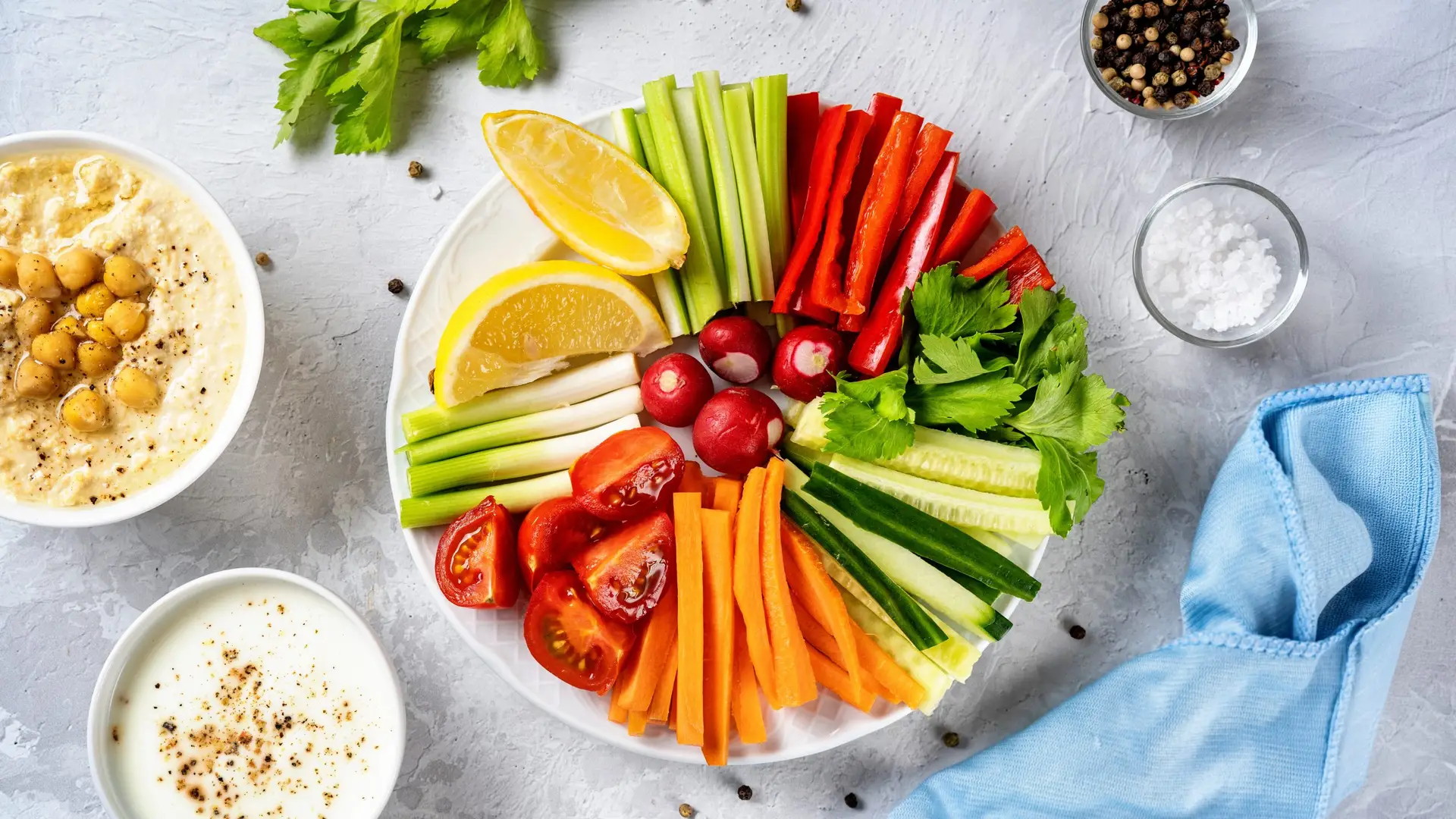 Close up of a plate with cut vegetables and dips